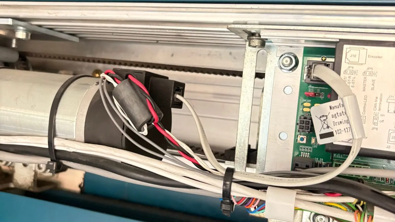 Automatic door operator with belt, motor and control board exposed in the header