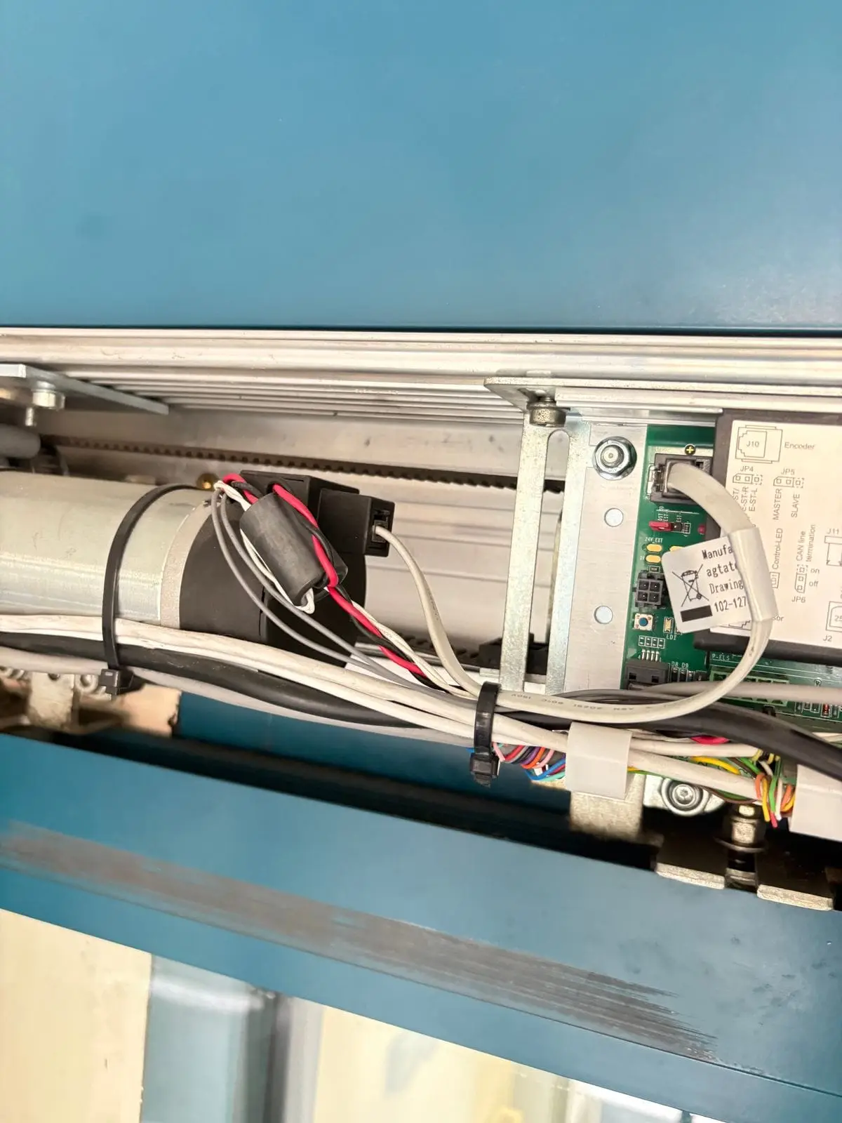 Automatic door operator with belt, motor and control board exposed in the header