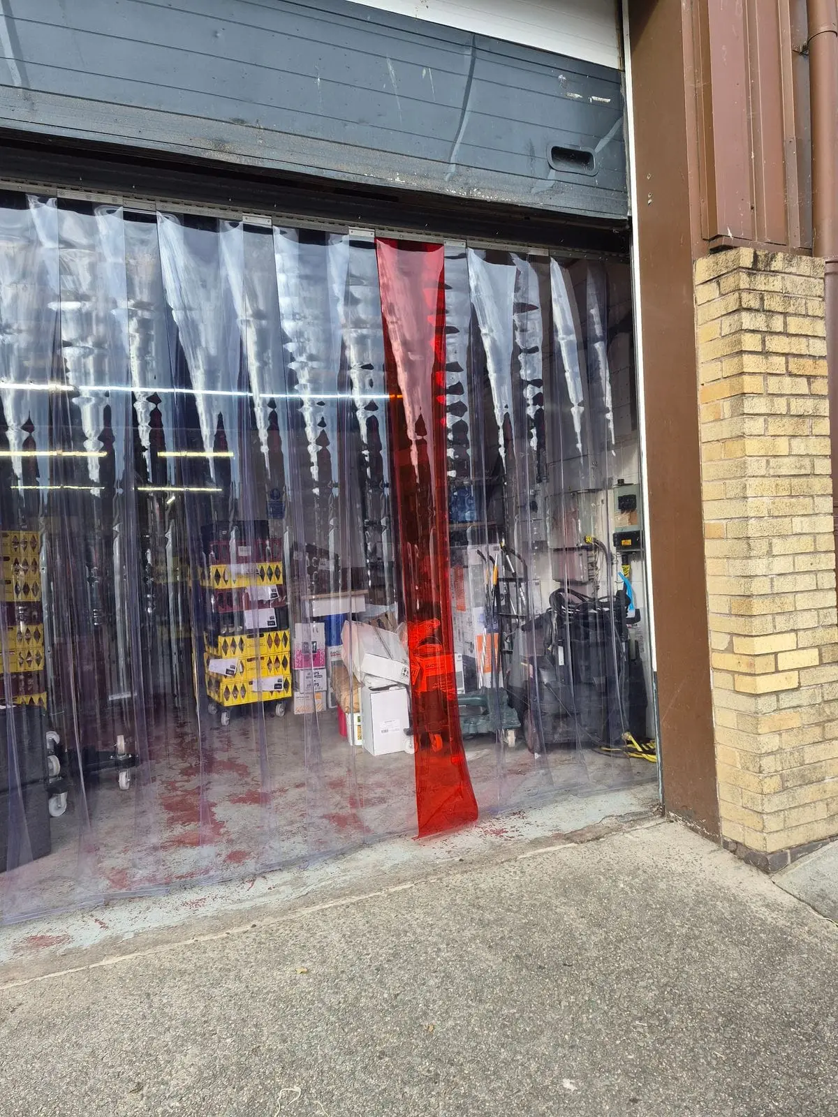 PVC strip curtain with a red guide strip fitted behind an insulated sectional door